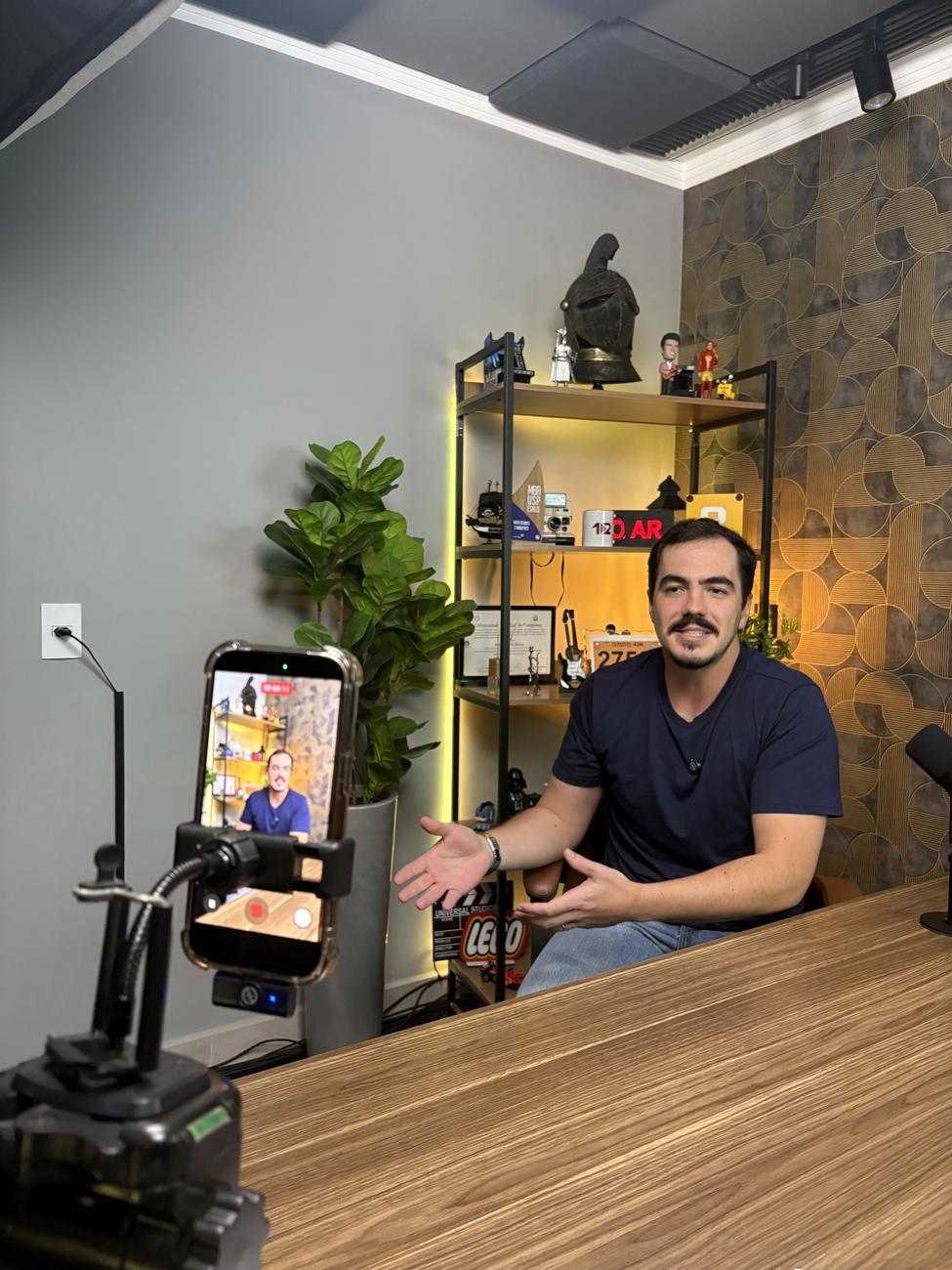 Matheus Duzzi gravando um vídeo em seu estúdio, com o celular no tripé